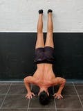 Assisted handstand push-ups facing the wall